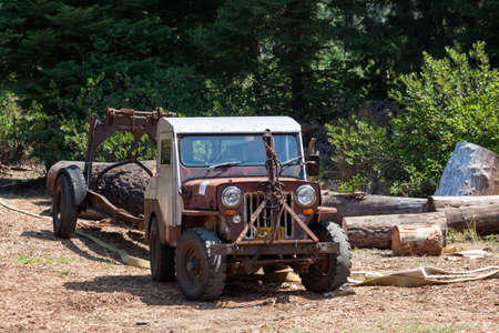 Prospect, Oregon / USA - August 16, 2014:  An antique Jeep with a trailer hauling a large log at the Prospect Hillbilly Jamboree and Timber Carnival in Prospect, Oregon.のeditorial素材