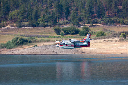 Lost Creek Lake near Prospect,  Oregon / USA - September 7, 2014:  A small fire fighting plane prepares to scoop water as it comes in low over Lost Creek Lake near Prospect, Oregon.のeditorial素材