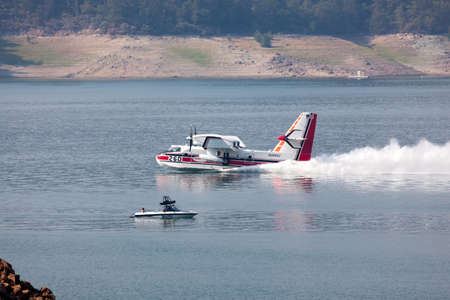 Lost Creek Lake near Prospect,  Oregon / USA - September 7, 2014:  A small fire fighting plane skims the lake surface to scoop up water at Lost Creek Lake near Prospect, Oregon.のeditorial素材