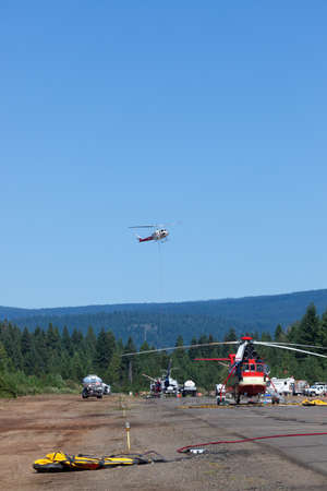 Prospect,  Oregon / USA - September 9, 2014:  A large helicopter named "The Pres" on the runway and a smaller one in the air leaving to fight the 790 Fire near Prospect, Oregon.のeditorial素材