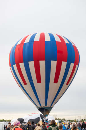 Albuquerque,  New Mexico / USA - October 8, 2014:  A red, white, and blue hot air balloon takes off among a large crowd at the Balloon Fiesta in Albuquerque, NM.のeditorial素材
