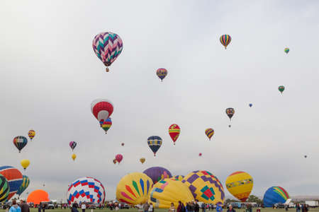 Albuquerque,  New Mexico / USA - October 8, 2014:  Several hot air balloons raising up into a cloudy morning sky at the Balloon Fiesta in Albuquerque, NM.のeditorial素材