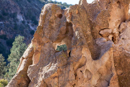 Ancient sandstone rocks eroded by time to form elaborate shapes and holes in the desert landscape of Frijoles Canyon in Bandelier National Monument, new Mexico.の写真素材