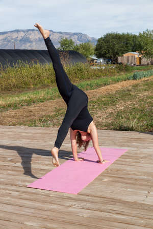 A woman participating in an afternoon outdoor yoga class on a sunny day at a farm.の写真素材