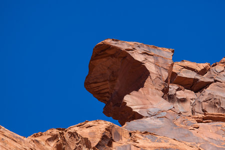 Sandstone walls at the top of Glen Canyon that have been eroded for thousands of years to form peculiar shapes against the clear blue sky background.の写真素材