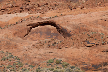 An eye shaped sandstone arch beginning to form in the walls of Glen Canyon above the Colorado River.の写真素材