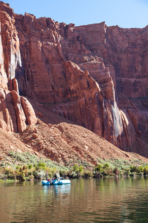 The inside point of Glen Canyon's Horseshoe Bend from the Colorado River with light sparkles on the surface and sunny clear sky in the distance.の写真素材
