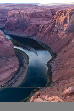 A boat on the Colorado River which looks tiny in comparison to its surroundings is coming into the famous Horseshoe Bend of Glen Canyon in Arizona.の写真素材