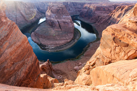 Giant orange sandstone boulders create a frame to view the famous Horseshoe Bend in the Colorado River which runs through Glen Canyon in Arizona.の写真素材