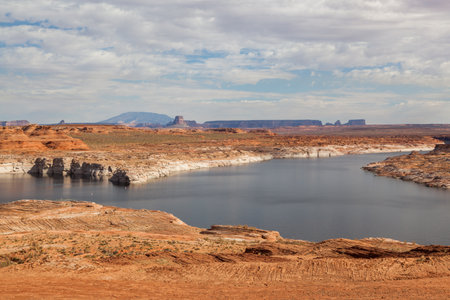 Lake Powell with a receding water level surrounded by desert landscape and Tower Butte in the distance.の写真素材