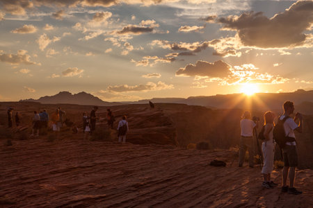 Horseshoe Bend, Arizona / USA - October 25, 2014:  Several tourists dot the landscape at Horseshoe Bend near Page, Arizona to look over the cliff edge at sunset to see the Colorado River below.のeditorial素材