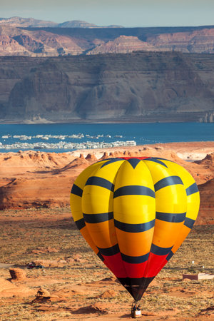 Page, Arizona / USA - October 31, 2014:  A participant in the Lake Powell Balloon Regatta floats close to the ground with Lake Powell and marina in the distance.のeditorial素材