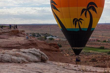 Page, Arizona / USA - October 31, 2014:  A participant in the Lake Powell Balloon Regatta floats next to sandstone rocks and people taking pictures in Page, Arizona.のeditorial素材