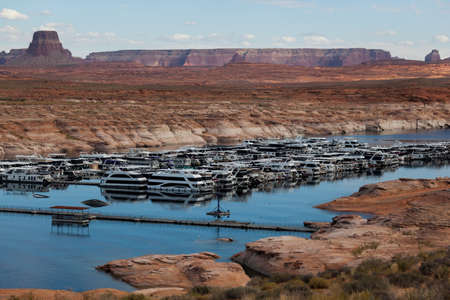 Page, Arizona, USA - October 31, 2014:  A row of sightseeing cruise boats docked in Antelope Point Marina on Lake Powell  with Tower Butte and Navajo Mountain in the distance in Arizona.のeditorial素材