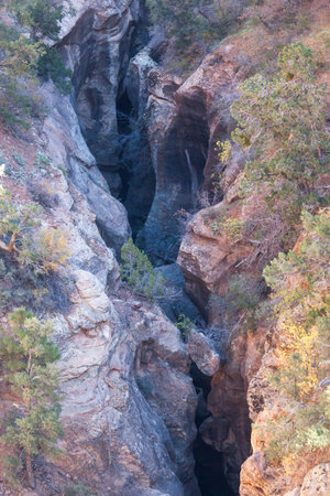 Looking down on a slot canyon that has been carved out of rock over years by fast moving water eroding the sandstone in Zion National Park, Utah.の写真素材