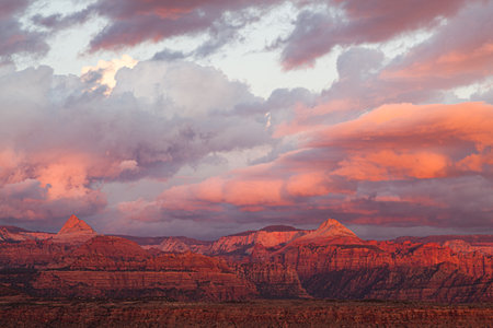 The dramatic landscape of Zion National Park from the Western side glowing in the sunset's fading light with storm clouds low in the sky.の写真素材