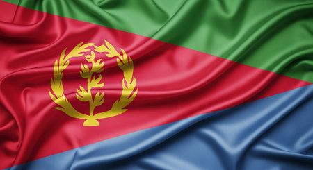 Eritrea flag waving in silk fabric. National symbol background for patriotic nation in africa. Represents country red green blue.の素材
