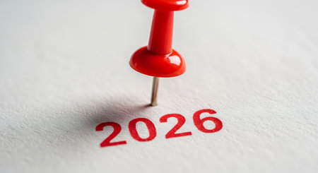 Close up of 2026 written on paper with a red pin. Planning for year 2026. Pinned date concept. Focus on future business goals.の素材