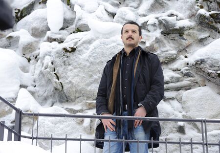 Portrait of a handsome young man in a full-length on the street in winterの写真素材