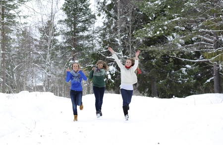Three girls run on the forest path