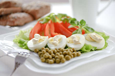 Boiled eggs on the leaves of lettuce and green peas