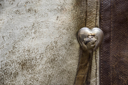 Old Western Worn Leather Chaps Detail with a Silver Heart Buckleの写真素材