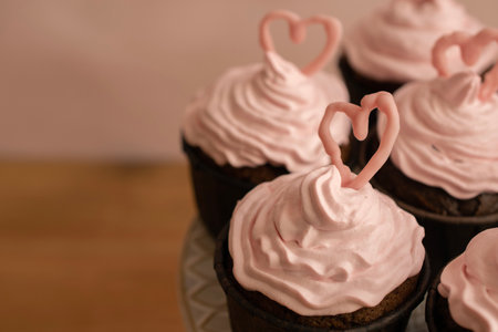 Cupcakes with pink buttercream frosting and a heart-shaped chocolate on top of each of them.