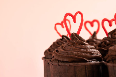 Chocolate cupcakes with red hearts on pink background, closeupの写真素材