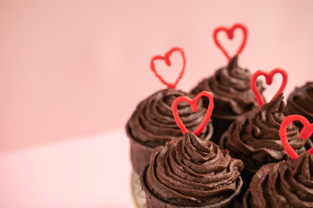 Chocolate cupcakes with red hearts on pink background. Valentines day concept.の写真素材