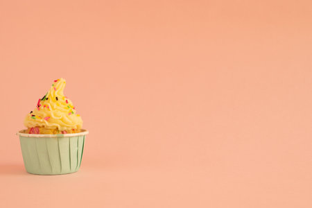 A cupcake with butter cream frosting on pink background with copy space.の写真素材