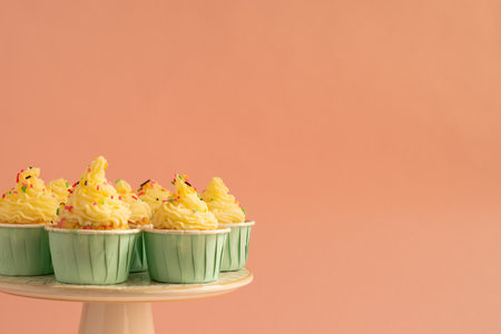 Cupcakes with butter cream frosting and sprinkles on pastel pink background.の写真素材