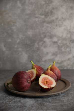 Ripe figs on a plate on a gray concrete-like background.の写真素材