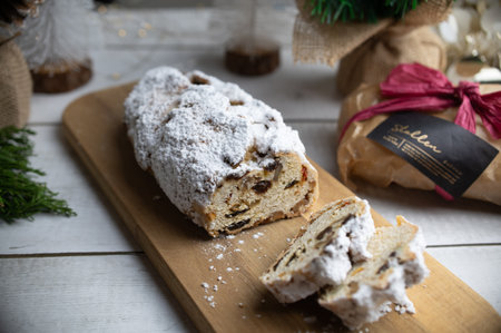 Christmas stollen, German christmas bread, with dried fruit, nuts and powdered sugar on wooden backgroundの写真素材
