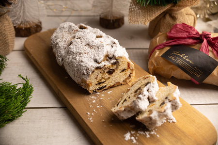 Christmas stollen, German christmas bread, with dried fruit, nuts and powdered sugar on wooden backgroundの写真素材
