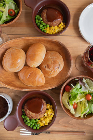 Dishes served at a dining table with Japanese hamburger steak with demi-grace sauce as a main dish.の写真素材