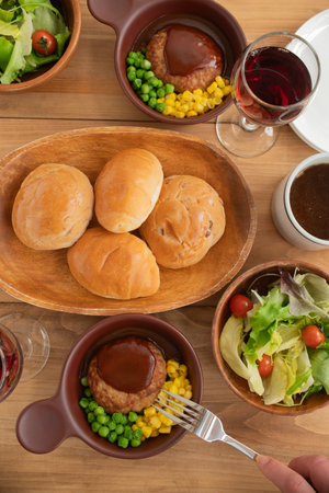 Dishes served at a dining table with Japanese hamburger steak with demi-glace sauce as a main dish.の写真素材