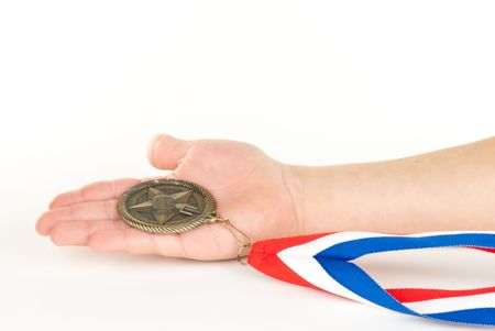 Child's hand holding a medal on white background.の写真素材