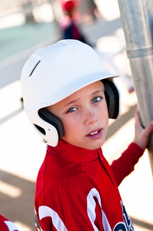 Little league baseball player in the dugout waiting to bat の写真素材