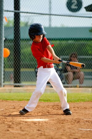 Youth baseball player swinging the bat.の写真素材