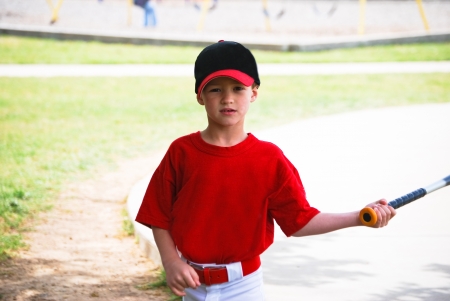 Youth baseball boy holding bat looking at camera.の写真素材