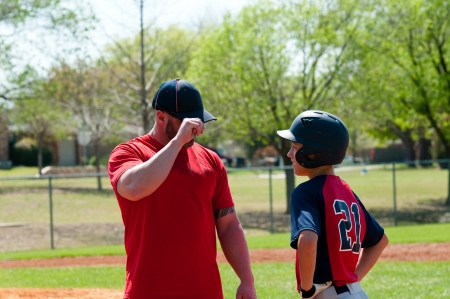 Baseball coach giving signals to teen playerの写真素材