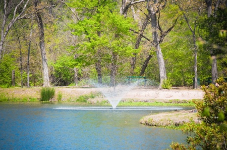 Horizontal view of a beautiful water fountain at a pond.の写真素材