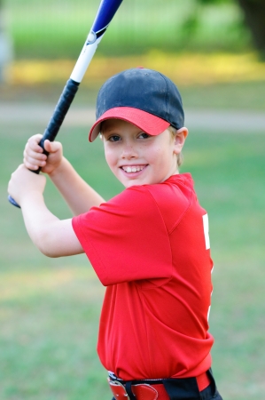 Portrait of little league baseball boy holding bat.の写真素材
