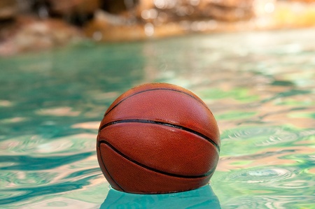 Basketball floating in swimming pool water の写真素材