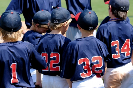 Team of baseball boys during a game in a huddle.