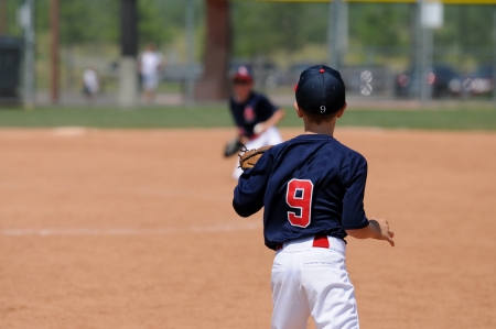 Youth baseball boy on first base waiting on ball.の写真素材
