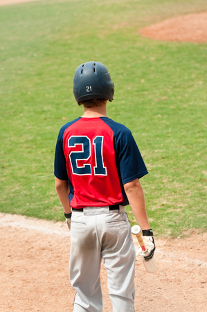 Teen boy baseball player looking at the pitcher.のeditorial素材