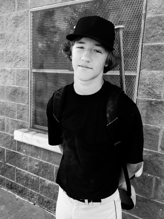 Outdoor black and white portrait of teen high school baseball player holding baseball bag.の写真素材