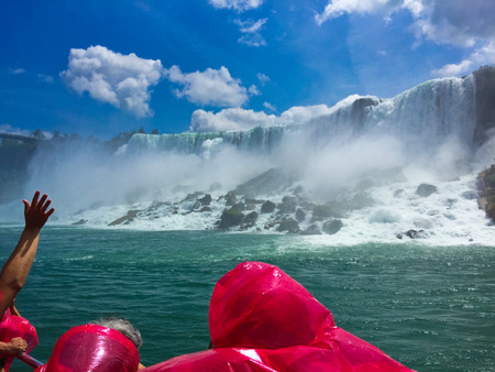 Beautiful Niagara Falls from on a boat with tourist wearing rain jackets.の写真素材