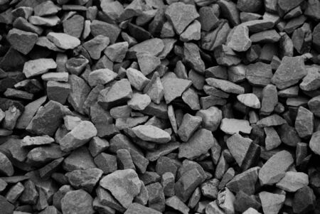 Black and white photo of pile of pebble rocks as background.